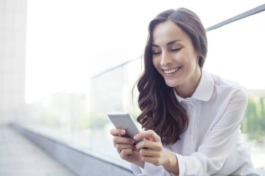 İş kadını akıllı telefon kullanıyor.