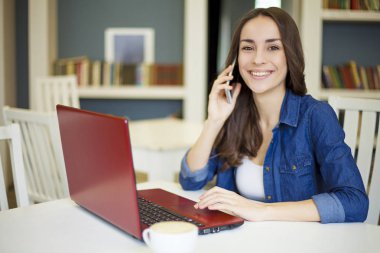 Kadın cep telefonuyla konuşuyor.