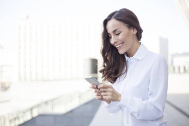 İş kadını akıllı telefon kullanıyor.