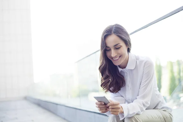 İş kadını akıllı telefon kullanıyor.