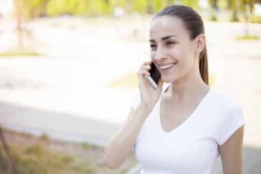 Kadın cep telefonuyla konuşuyor.