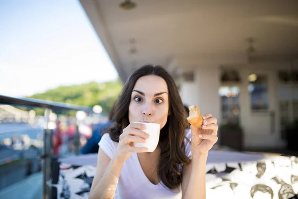 Donna mangiare croissant e bere caffè — Foto Stock