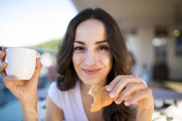 Mujer comiendo croissant y bebiendo café —  Fotos de Stock