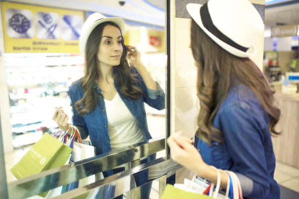 Aynaya bakmak genç bir kadın — Stok fotoğraf