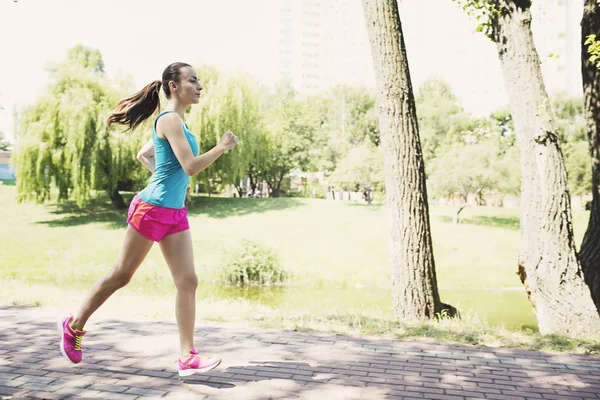 Kvinnan joggar i parken — Stockfoto
