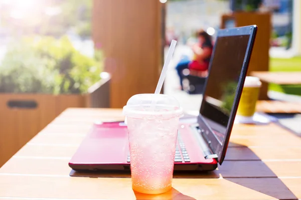 laptop with cold drink on table
