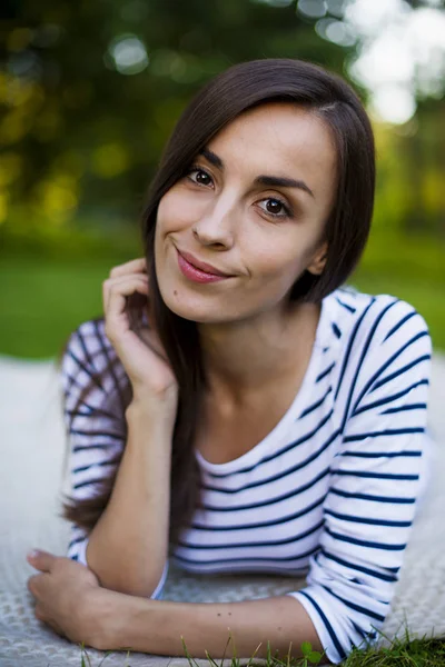 Jonge vrouw liggend op het gras — Stockfoto