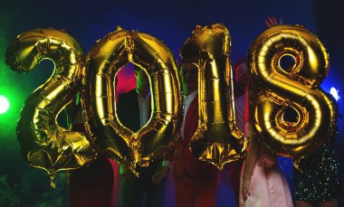 Arka plan dans eden bir grup genç insan üzerinde rakamlar şeklinde balonlar altın bileşimi. Yeni yıl 2018. Festival yeni yıl parti ya da disko.