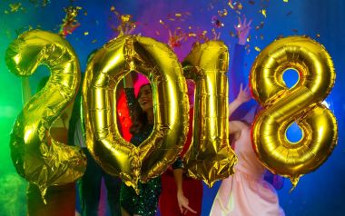 Arka plan dans eden bir grup genç insan üzerinde rakamlar şeklinde balonlar altın bileşimi. Yeni yıl 2018. Festival yeni yıl parti ya da disko.