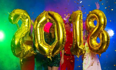 Arka plan dans eden bir grup genç insan üzerinde rakamlar şeklinde balonlar altın bileşimi. Yeni yıl 2018. Festival yeni yıl parti ya da disko.