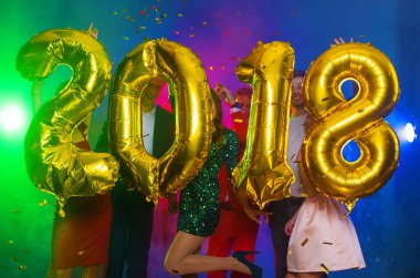 Arka plan dans eden bir grup genç insan üzerinde rakamlar şeklinde balonlar altın bileşimi. Yeni yıl 2018. Festival yeni yıl parti ya da disko.