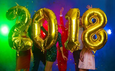 Arka plan dans eden bir grup genç insan üzerinde rakamlar şeklinde balonlar altın bileşimi. Yeni yıl 2018. Festival yeni yıl parti ya da disko.