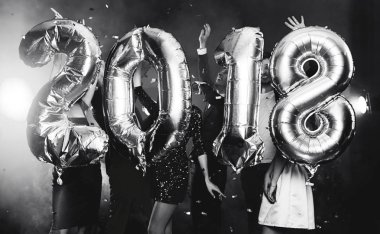 Arka plan dans eden bir grup genç insan üzerinde rakamlar şeklinde balonlar altın bileşimi. Yeni yıl 2018. Festival yeni yıl parti ya da disko. Siyah ve beyaz fotoğraf