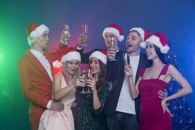 Arkadaş grubu parti. Neşeli in arkadaş grubu ile şampanya yılbaşı ya da Noel partisinde ile poz santa şapkalar.