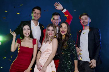 Birlikte eğlenelim. Taraf konfeti ile mutlu ve gülümseyerek arkadaşlar. İnsanlar ve tatil kavramı. Kutlama ve parti. Yeni yıl. Doğum günü