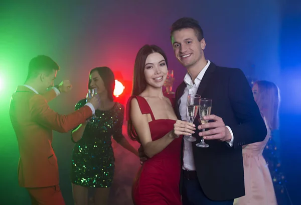 一群年轻快乐的朋友在聚会上跳舞 一个男人和一个女人在前台跳舞 无比的酒杯与香槟 — 图库照片