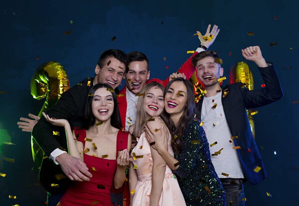 Поздравляем Вас с наступающим Новым годом и Рождеством Христовым! Счастливые и улыбающиеся друзья на вечеринке с конфетти. Понятие людей и праздников. Празднование и вечеринка. Новый год. День рождения
