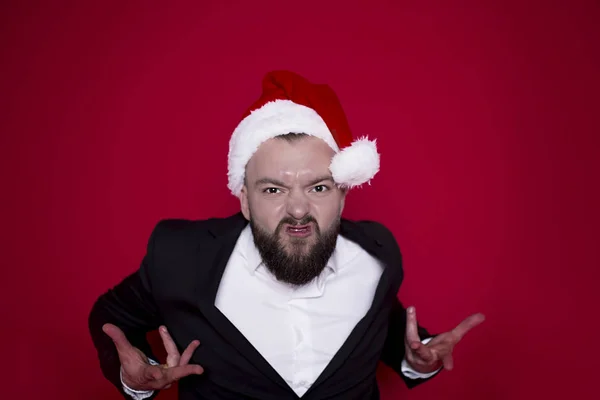 Komik Sakallı Adam Noel Baba Şapkalı Yüzleri Kırmızı Bir Arka — Stok fotoğraf