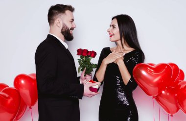 Aşık tatil tebrik ediyorum. Çiçek ve hediye için mutlu kadını Sevgililer Günü'nde veren gülümseyen adam.