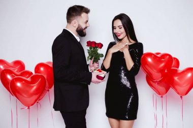 Aşık tatil tebrik ediyorum. Çiçek ve hediye için mutlu kadını Sevgililer Günü'nde veren gülümseyen adam.