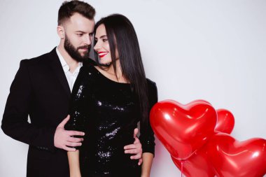 Bir güzel gülümseyen portresi yakın çift kucaklayan izole beyaz bir arka plan üzerinde siyah gece elbisesi içinde sevgi dolu.