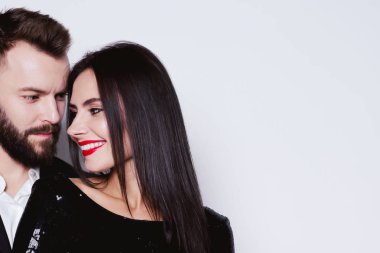 Bir güzel gülümseyen portresi yakın çift kucaklayan izole beyaz bir arka plan üzerinde siyah gece elbisesi içinde sevgi dolu.