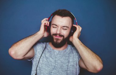 Benim en sevdiğim müzik. Güzel modern büyük kulaklıklar müzik gri bir arka plan üzerinde boy gülümseyerek.