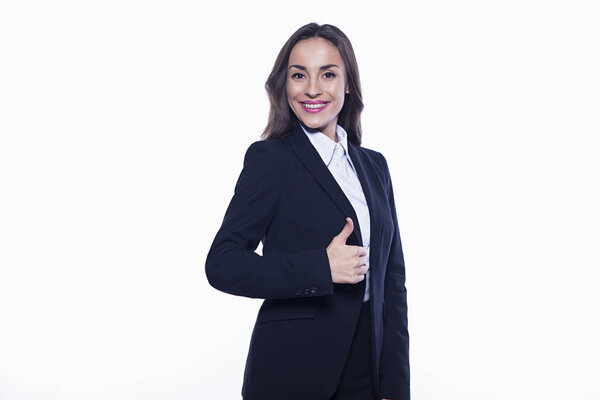 Good working day. Confident beautiful smiling young business woman in suit on white background isolated with a raised finger up