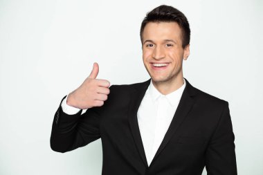 Bu iyi bir sonucudur. Akıllı rahat kıyafet şık yakışıklı gülümseyen modern işadamı kameraya bakar ve parmağını alır.