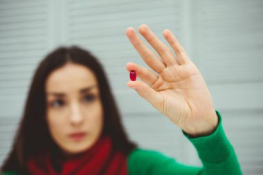 İlaç alımı. Onun el tableti su tutar fotoğraf kırmızı bir fular yatakta evde içinde genç bir kadın. Sağlık ve hastalık kavramı.