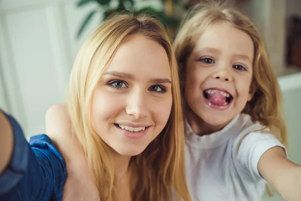 笑顔と幸せママと娘が抱き合っ自宅ソファの上 ママと娘は 楽しい時を過す — ストック写真