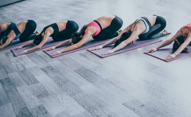 Çocuğun poz. Spor salonunda yoga yaparken genç güzel kadın çok ırklı grubudur. Açık veya yoga sınıfı