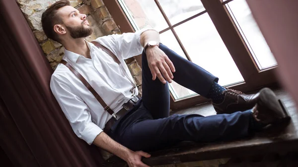 Close up portrait of handsome smiling bearded man in white shirt, guy looking on the window.