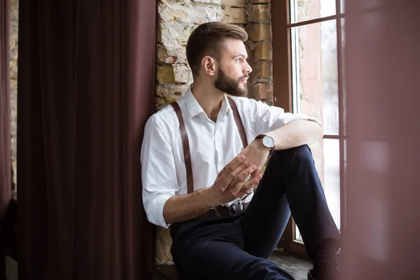 Close up portrait of handsome smiling bearded man in white shirt, guy looking on the window.