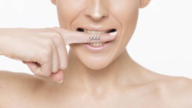 Fotoğraf güzel bir gülümseyen kadın yüzü temiz yukarıya kapatmak ve taze cilt, kız bir parmak dudakları için koyar..