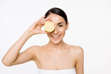 Genç güzel gülümseyen kadın halfs eller üzerinde beyaz izole limon ile