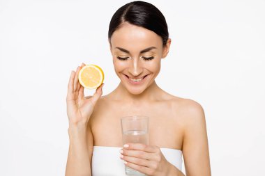 Genç güzel gülümseyen kadın halfs eller üzerinde beyaz izole limon ile