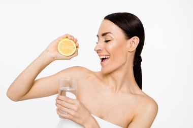 Genç güzel gülümseyen kadın halfs eller üzerinde beyaz izole limon ile