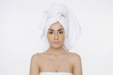 Gözlerinin altında yamalar. Cilt Bakımı gözlerinin altında. Kafasındaki bir havlu, bir duş sonra bir kız ile güzel genç gülümseyen kadın. Güzellik ve spa. Yüz ve vücut bakımı. Kozmetik.