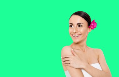 Temiz cilt ve çiçek beyaz arka plan üzerinde poz kafasına güzel genç gülümseyen kadın. Güzellik ve spa. Yüz ve vücut bakımı. Kadın sağlığı. Kozmetik.