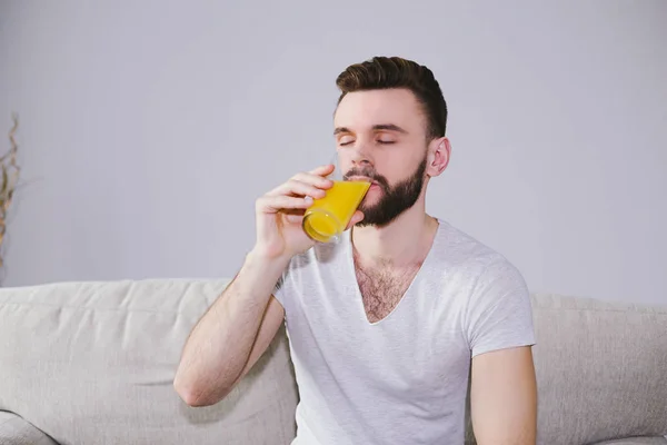 man drinking orange juice