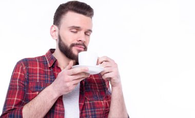 Genç yakışıklı adam kahve içiyor. 