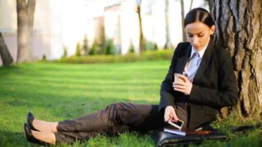 Kendine güvenen düşünme iş kadını rahatla ve içme kahve parkta çalışmaları sırasında break ve telefon görüşmesi için cevap