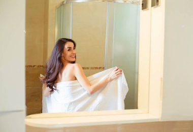 Güzel gülümseyen kadın duş alıyor.