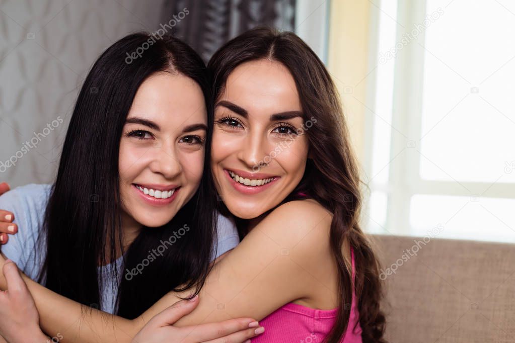 Funny girl friends or sisters relaxing together at home and have fun