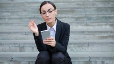 Mola açık havada, güzel kız öğrencinin üniversite merdivenlerde oturan akıllı telefon kullanan genç çekici iş kadın Close-Up