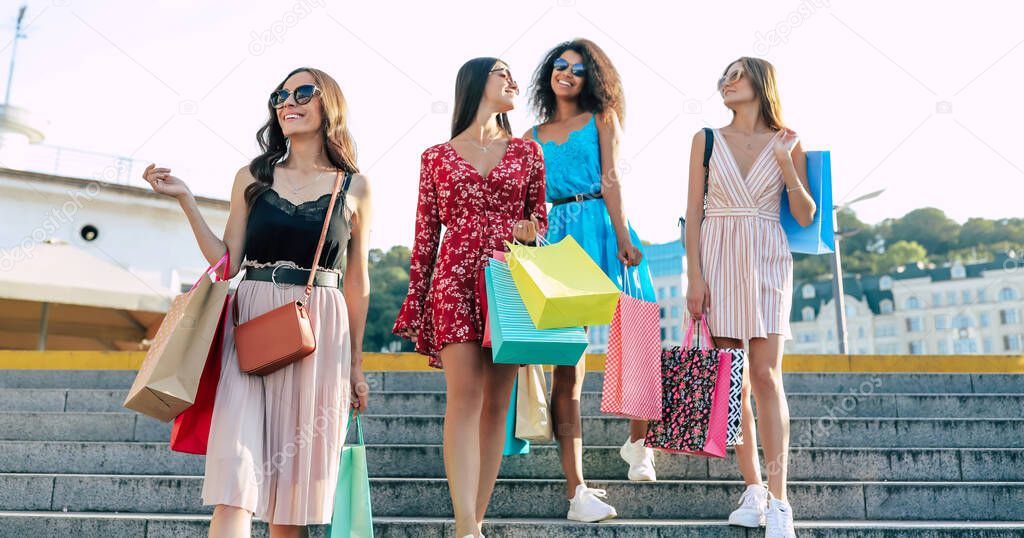 attractive and smiling young women with shopping bags, sale concept