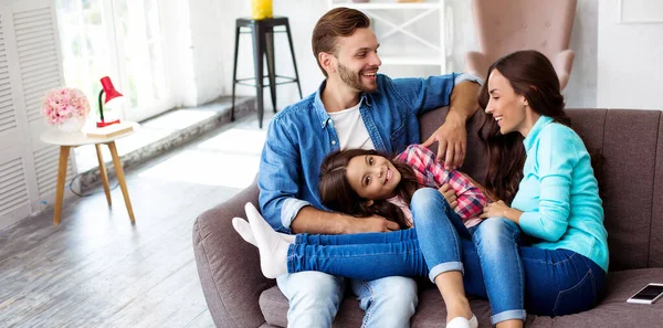 Glada Unga Föräldrar Med Liten Dotter Soffan Sin Lägenhet — Stockfoto