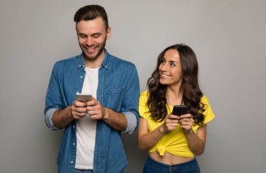 Stüdyo geçmişinde akıllı telefonları olan mutlu çift. 