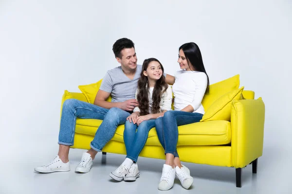 幸せな若い家族の肖像画黄色のソファに座って — ストック写真